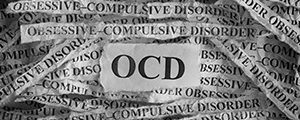 Obsessive compulsive disorder (OCD). Torn pieces of paper with the words Obsessive"u2013compulsive disorder. Concept Image. Black and White. Closeup.